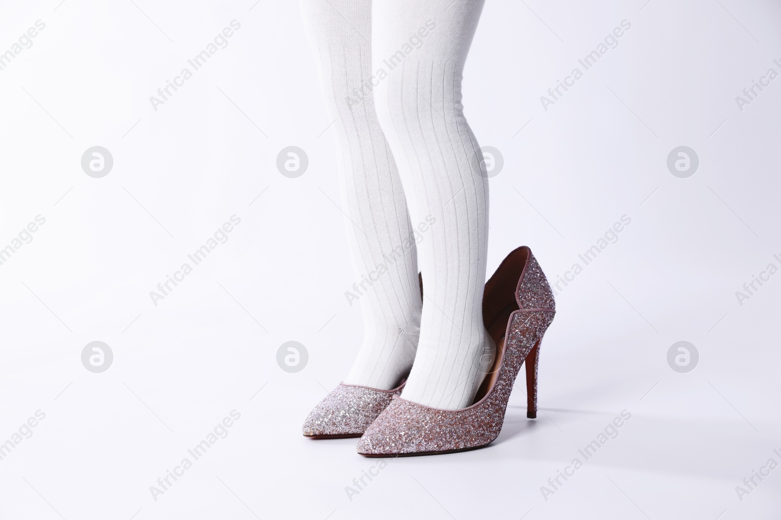 Photo of Child wearing tights and heels on white background, closeup