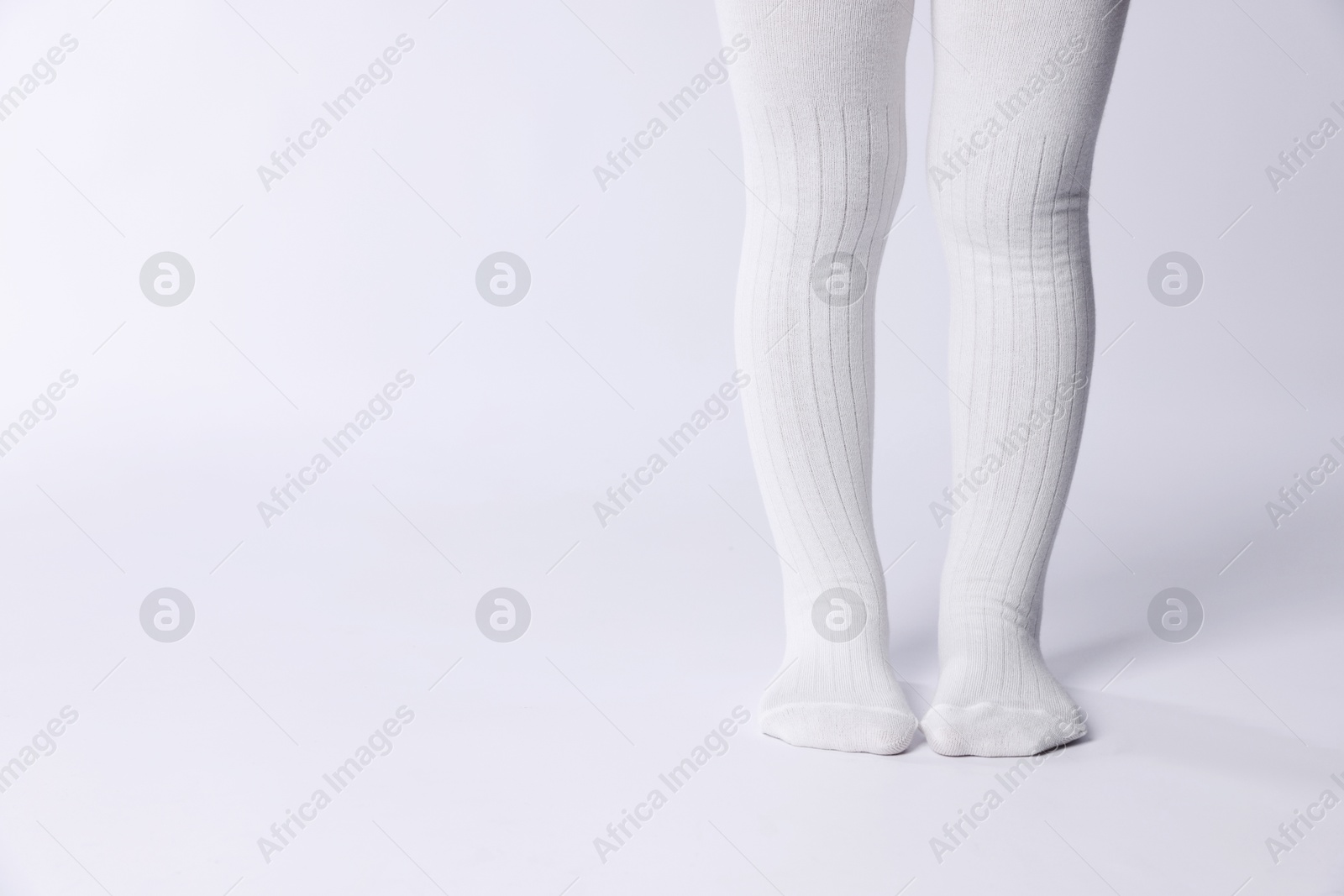 Photo of Child wearing tights on white background, closeup. Space for text