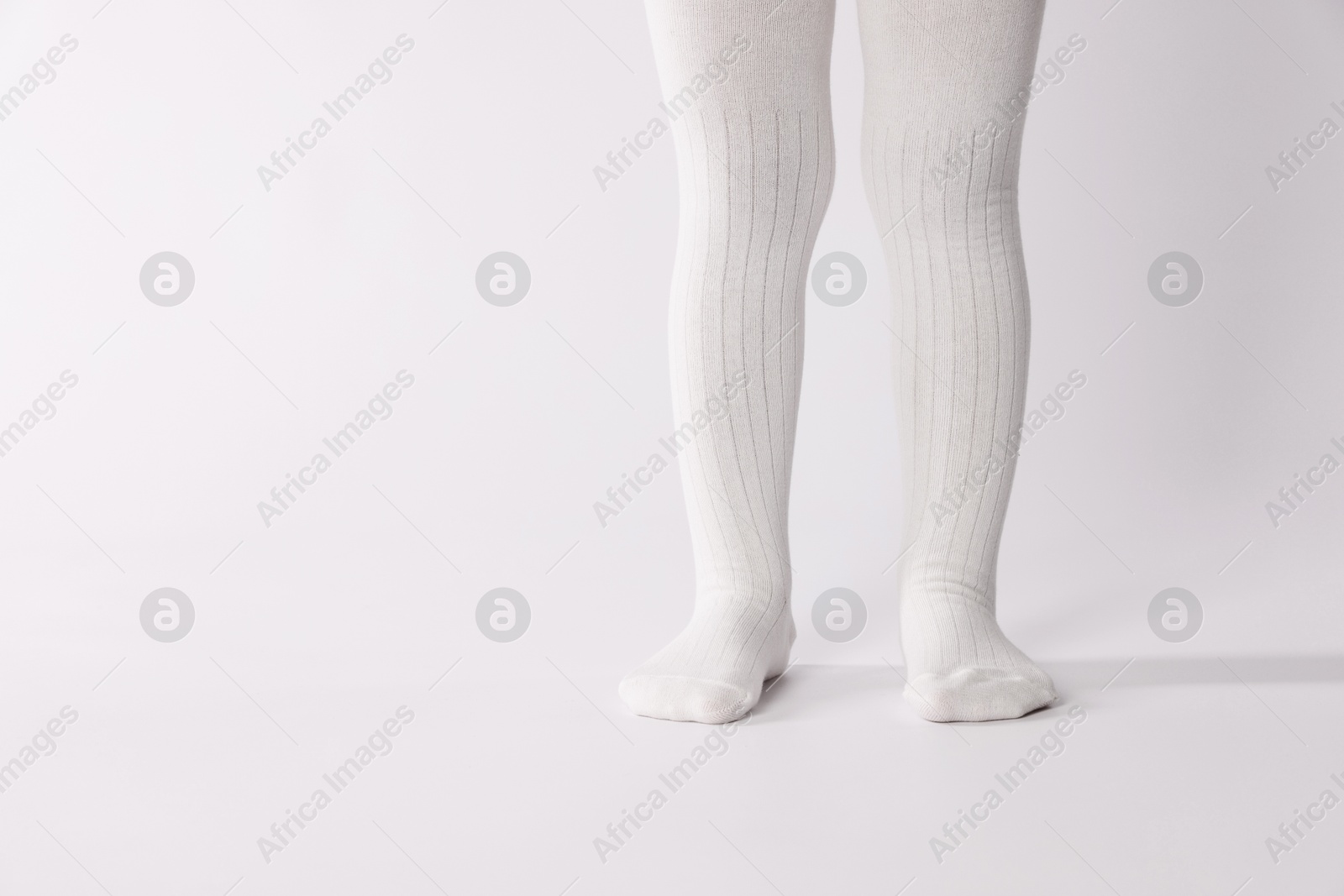 Photo of Child wearing tights on white background, closeup. Space for text