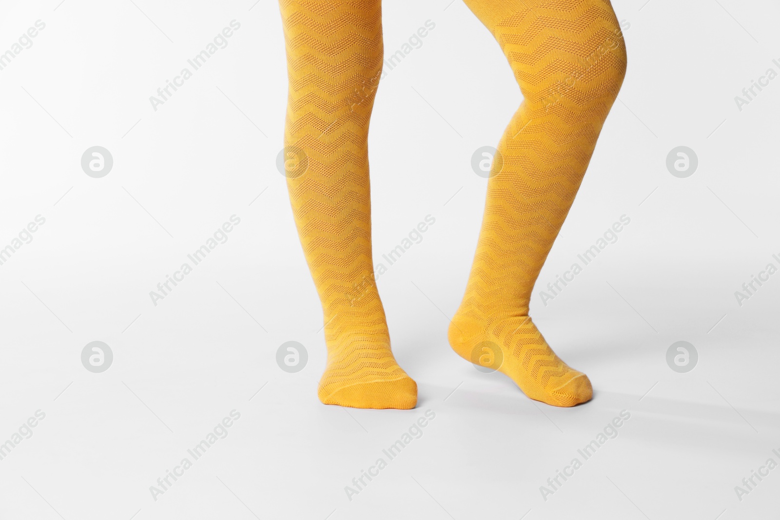 Photo of Child wearing bright tights on white background, closeup