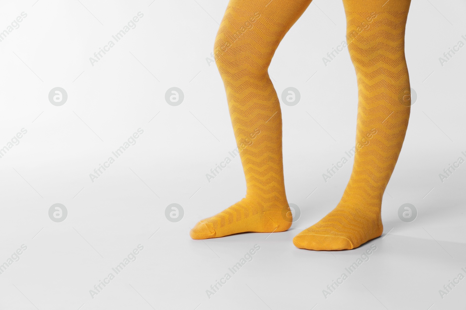 Photo of Child wearing bright tights on white background, closeup. Space for text