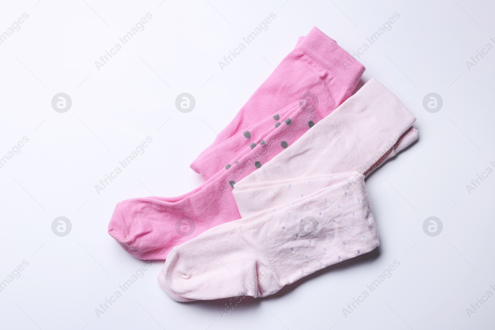 Photo of Beautiful pink child's tights on white background, top view