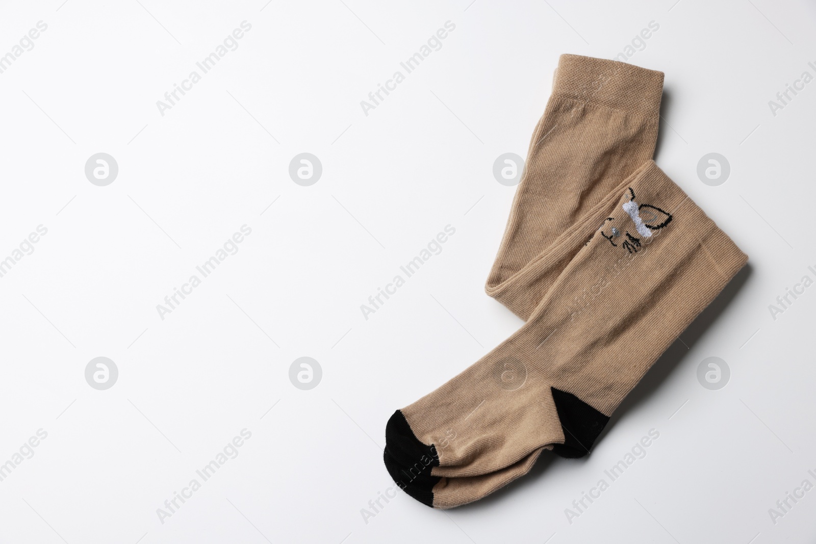 Photo of Beautiful brown child's tights on white background, top view. Space for text