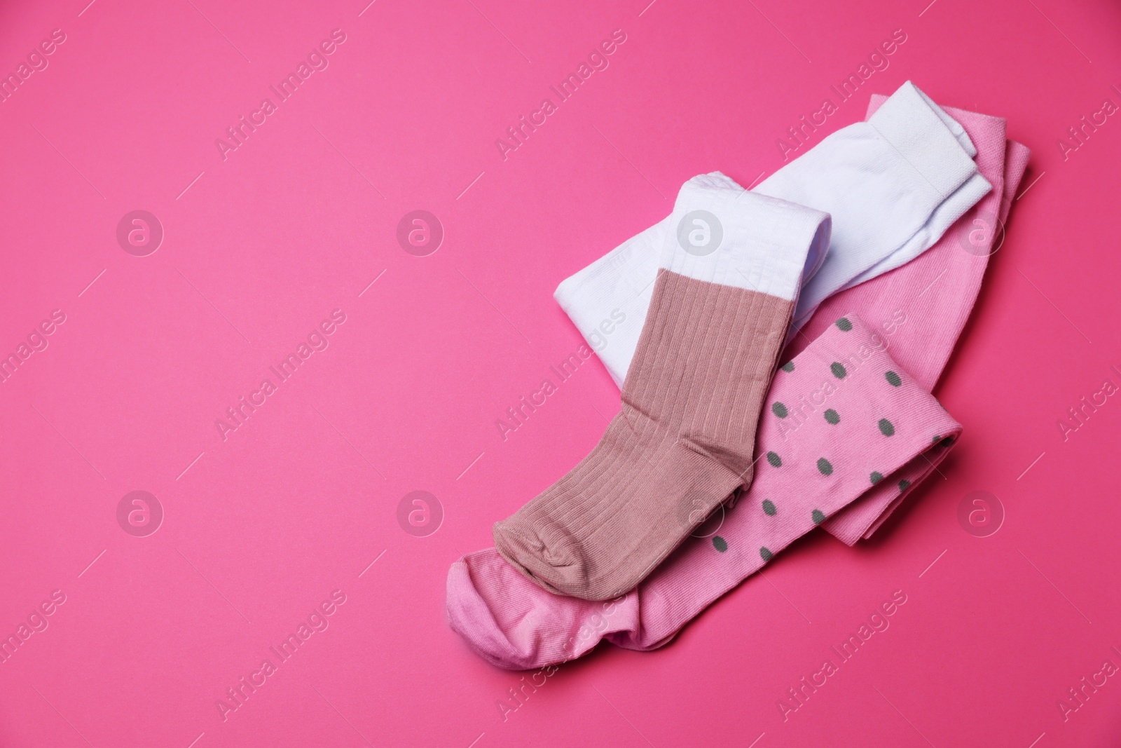 Photo of Different child's tights on pink background, above view. Space for text