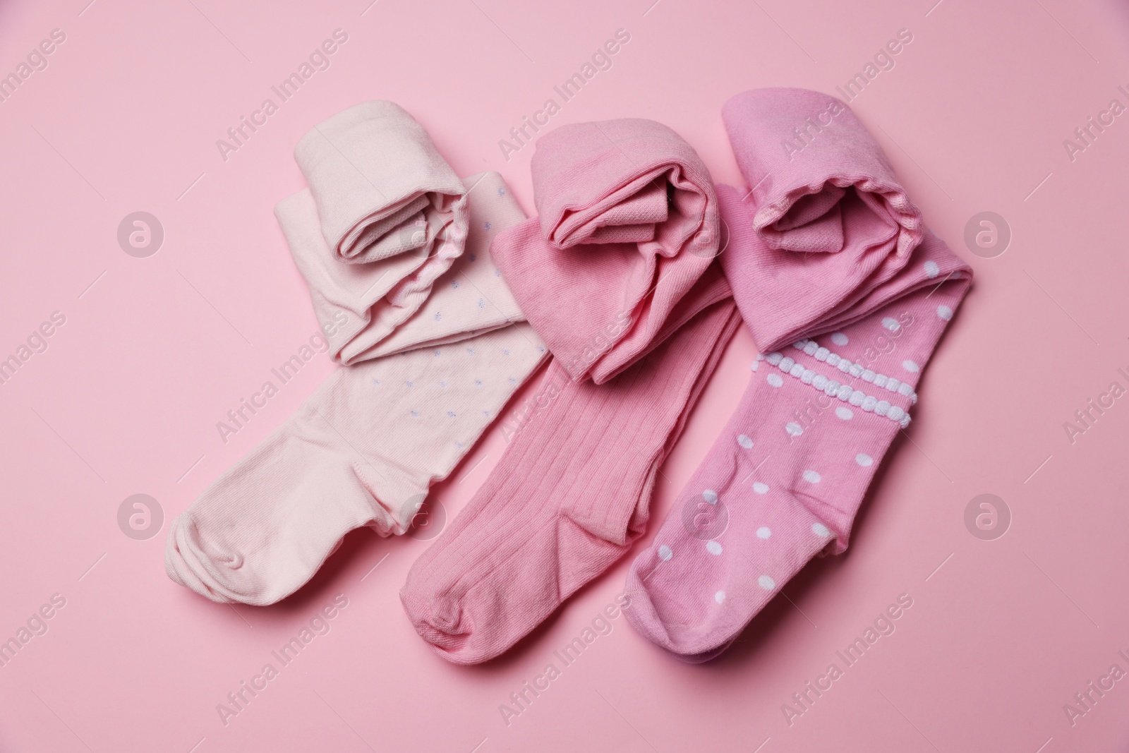 Photo of Beautiful child's tights on pink background, top view