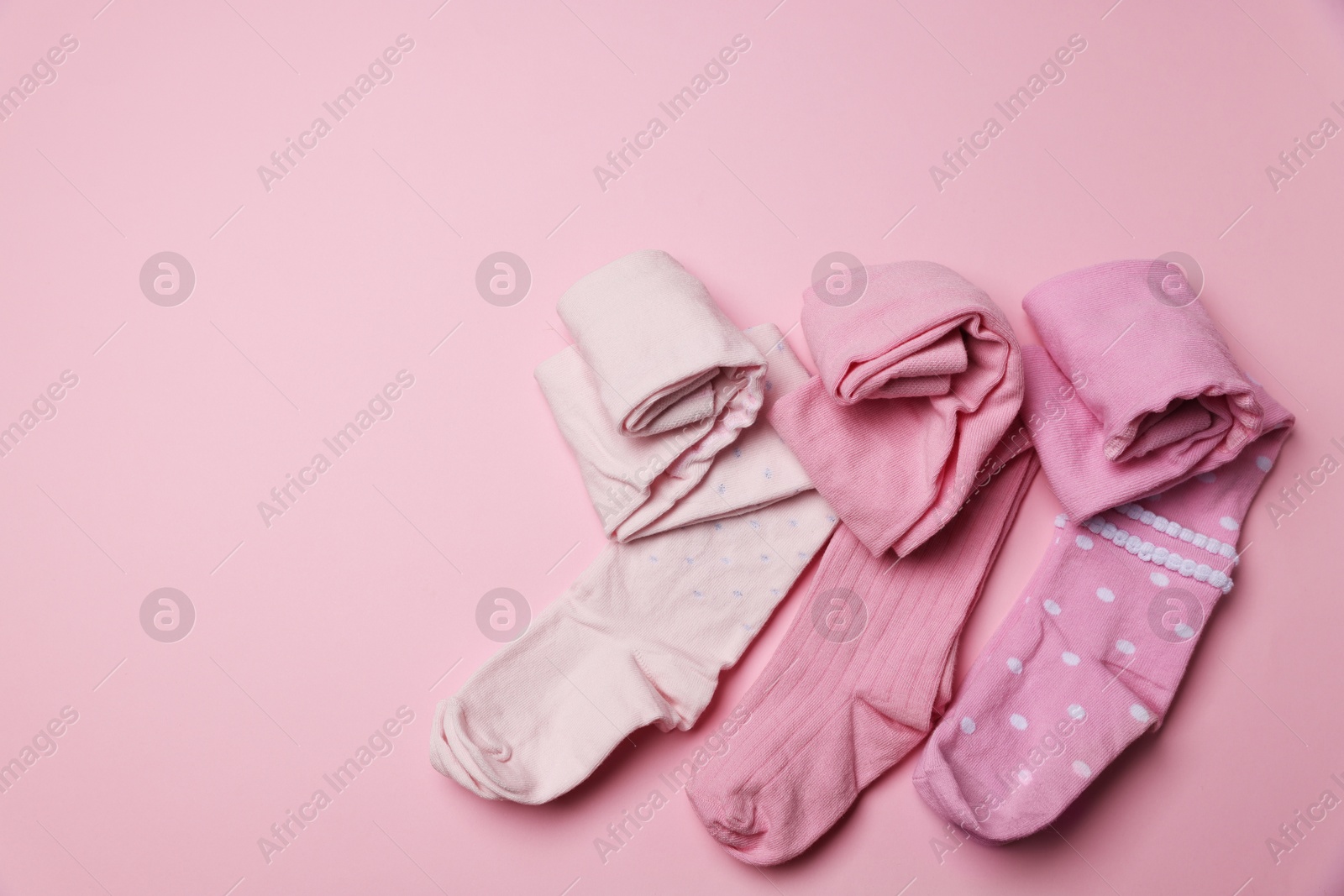 Photo of Beautiful child's tights on pink background, top view. Space for text