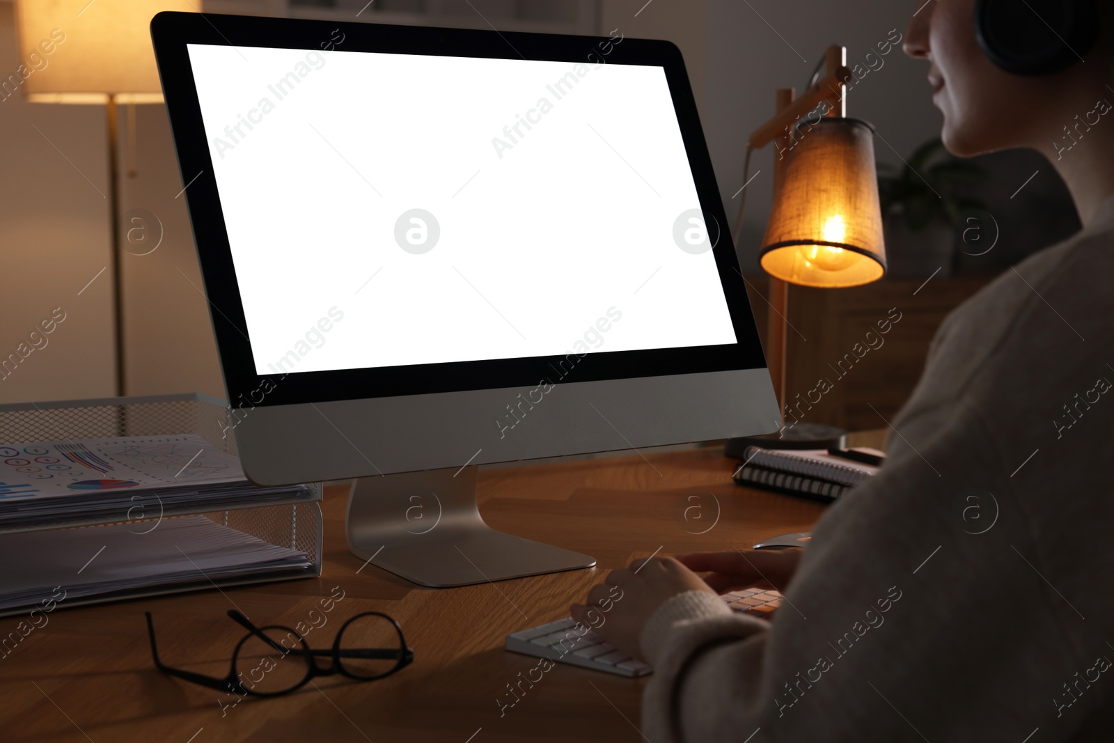 Photo of Woman working on computer at wooden table in office, closeup