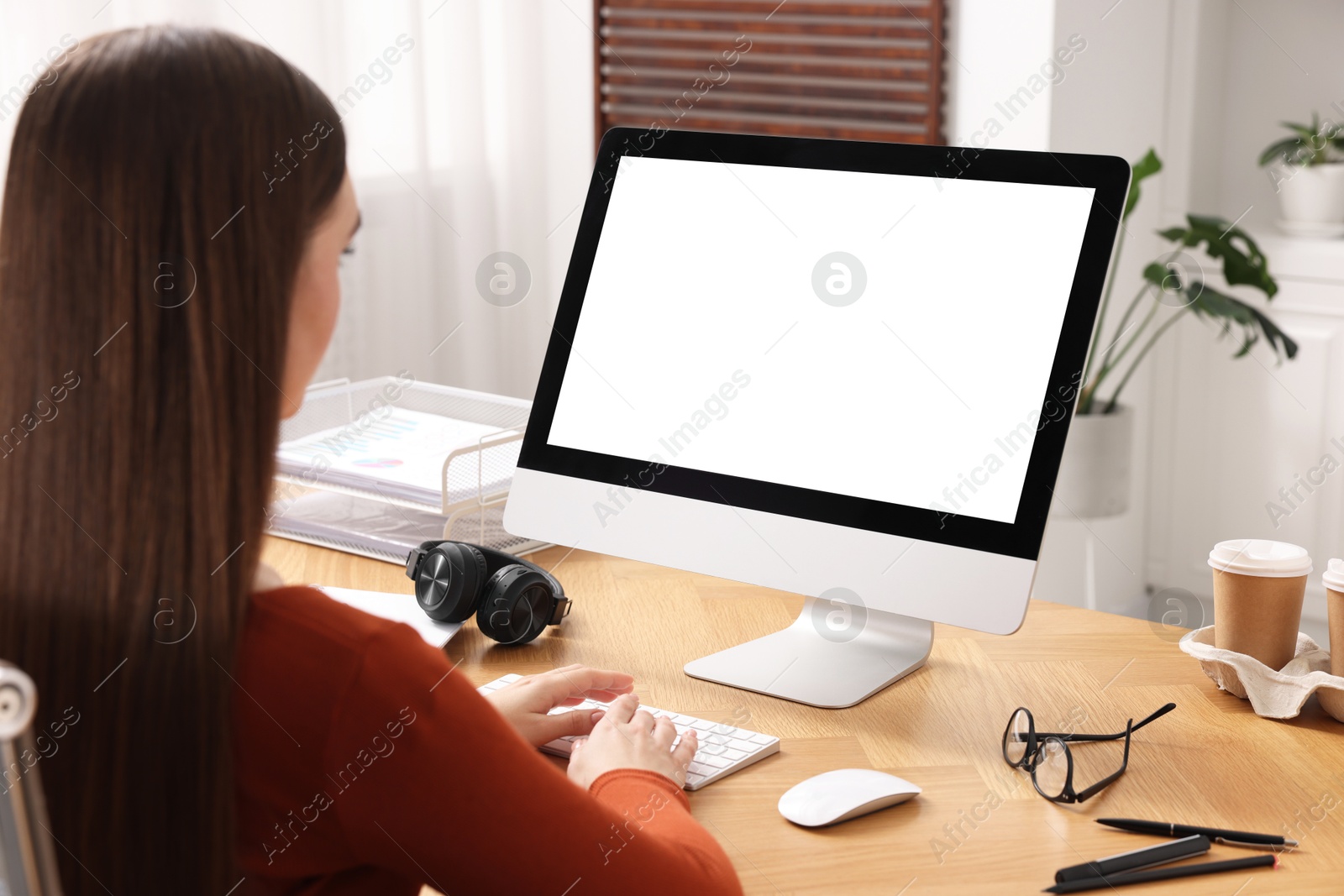 Photo of Woman working on computer at wooden table in office