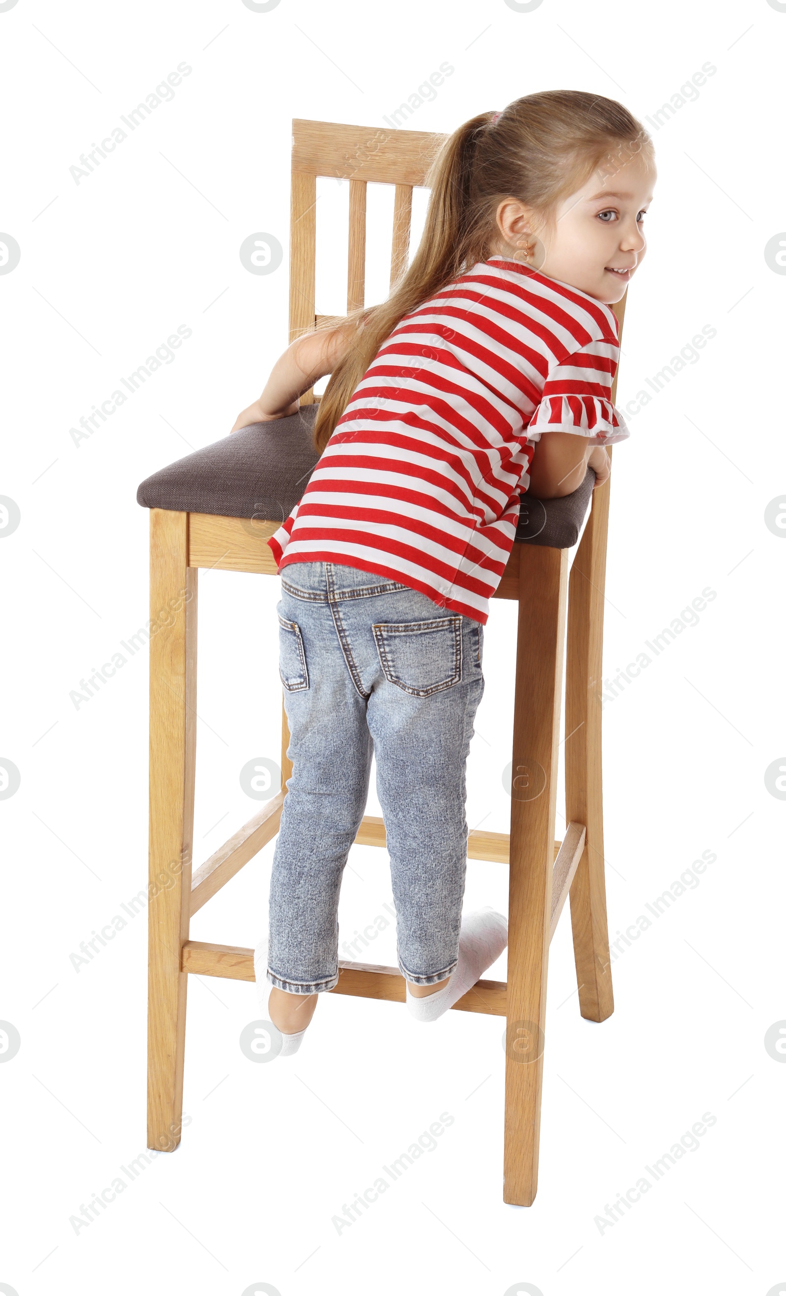 Photo of Little girl standing on stool against white background