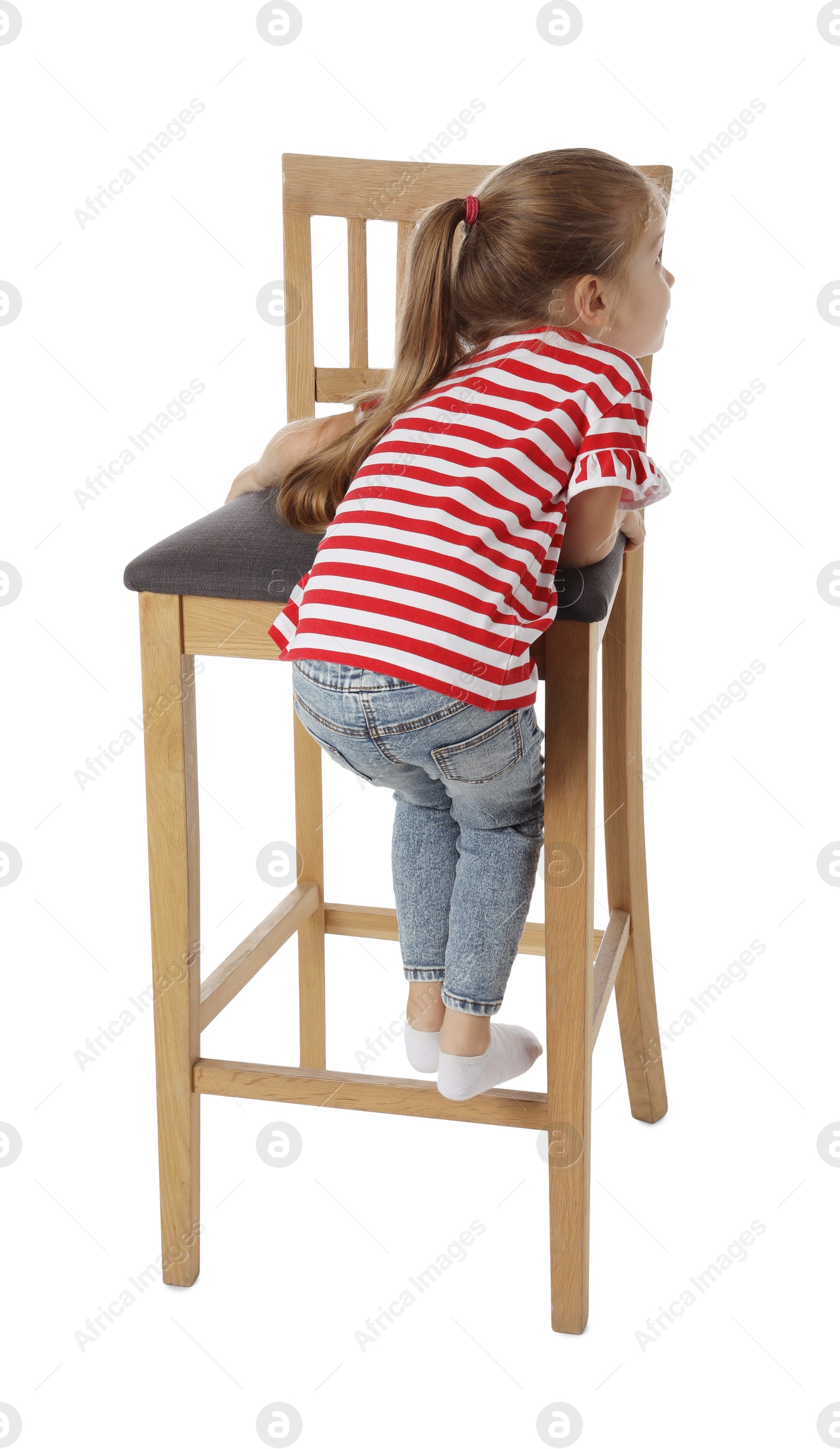 Photo of Little girl standing on stool against white background, back view