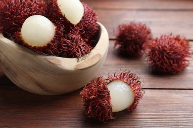 Photo of Delicious ripe rambutans on wooden table, closeup