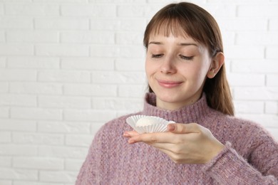 Photo of Beautiful woman with tasty mochi near white wall. Space for text