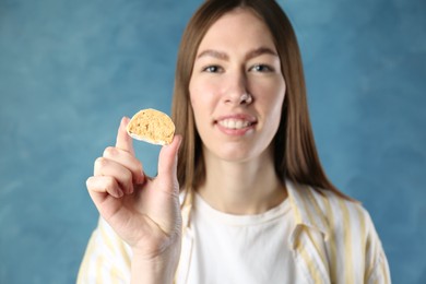 Photo of Smiling woman with tasty mochi on blurred blue background, selective focus