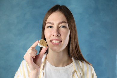 Photo of Smiling woman with tasty mochi on blurred blue background