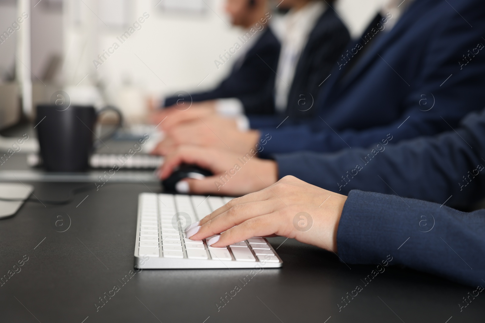 Photo of Technical support call center. Team of operators working at table in office, closeup