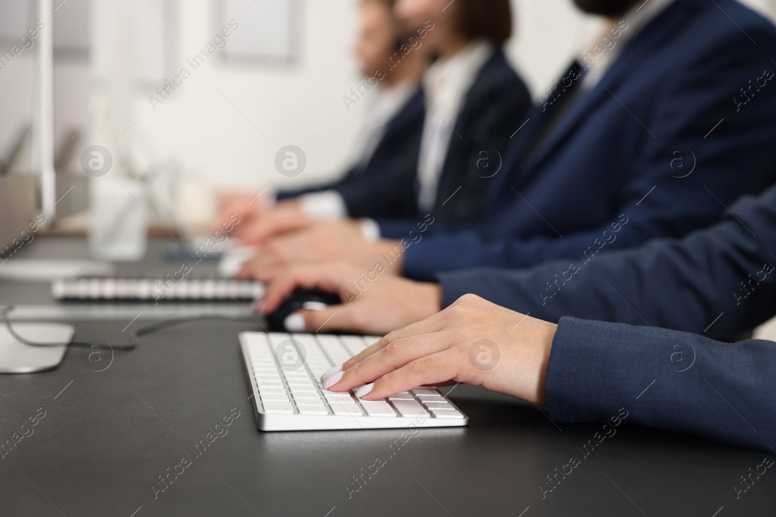 Photo of Technical support call center. Team of operators working at table in office, closeup