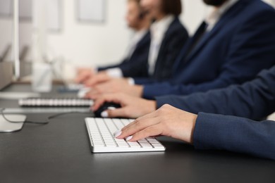 Photo of Technical support call center. Team of operators working at table in office, closeup