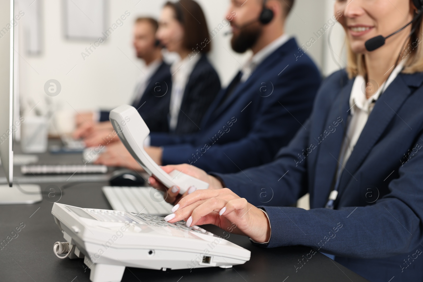 Photo of Technical support call center. Team of operators working at table in office, closeup