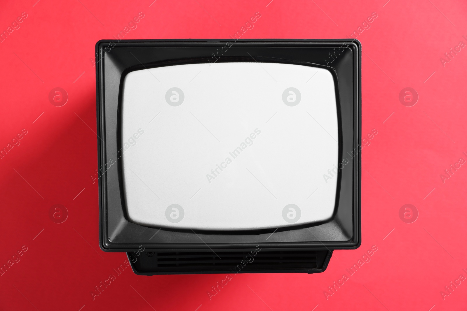 Photo of Retro tv set on red background, top view