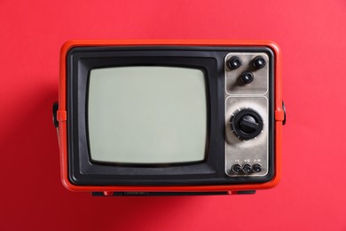 Photo of Retro tv set on red background, top view