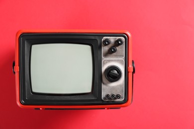 Photo of Retro tv set on red background, top view