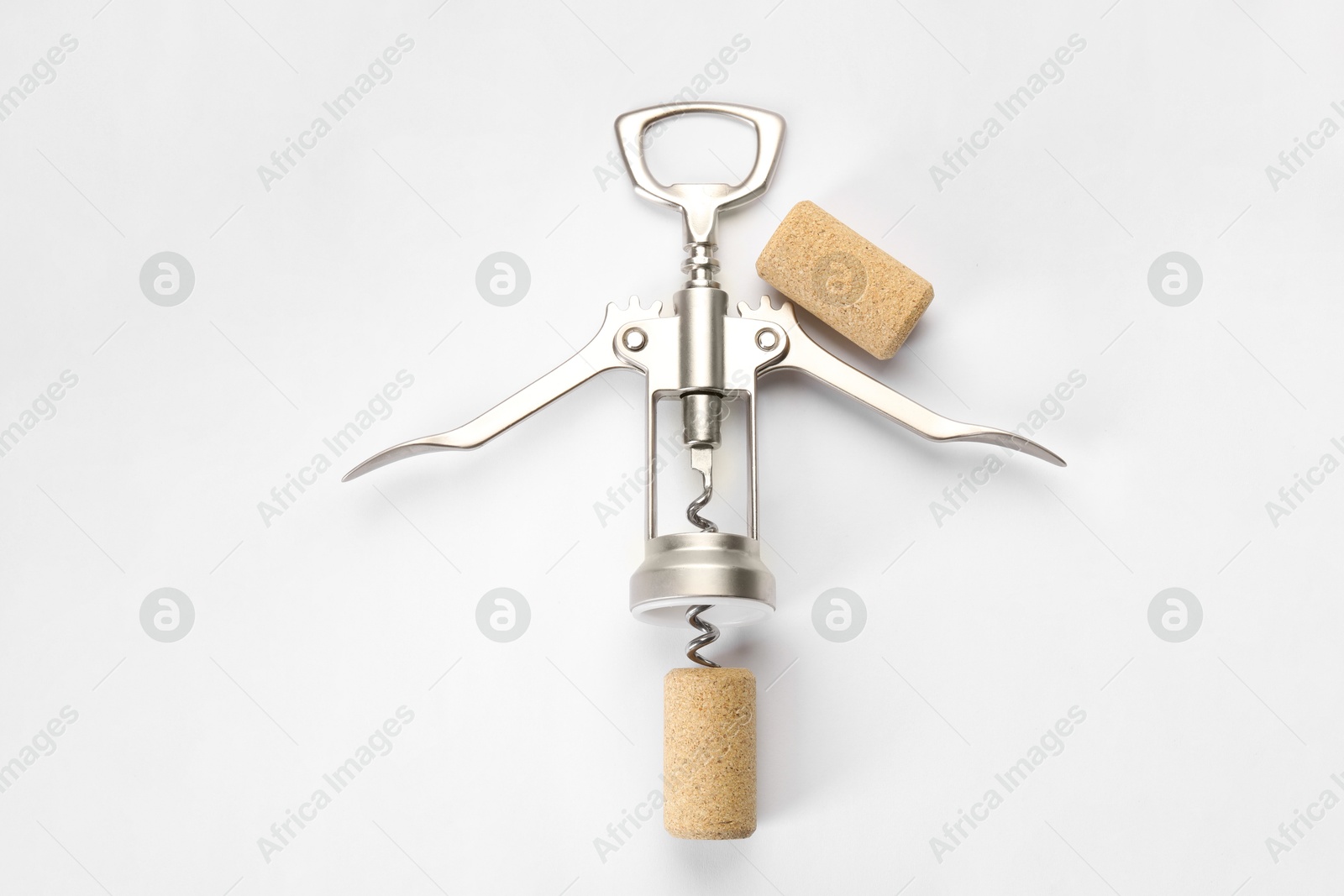 Photo of Wing corkscrew and corks on white background, top view