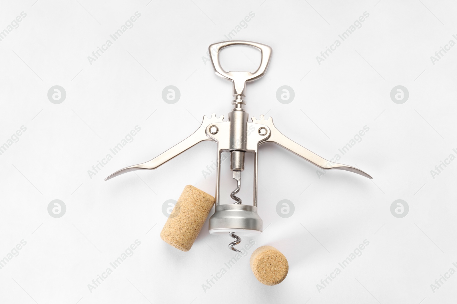 Photo of Wing corkscrew and corks on white background, top view