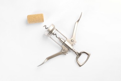 Photo of Wing corkscrew and cork on white background, top view