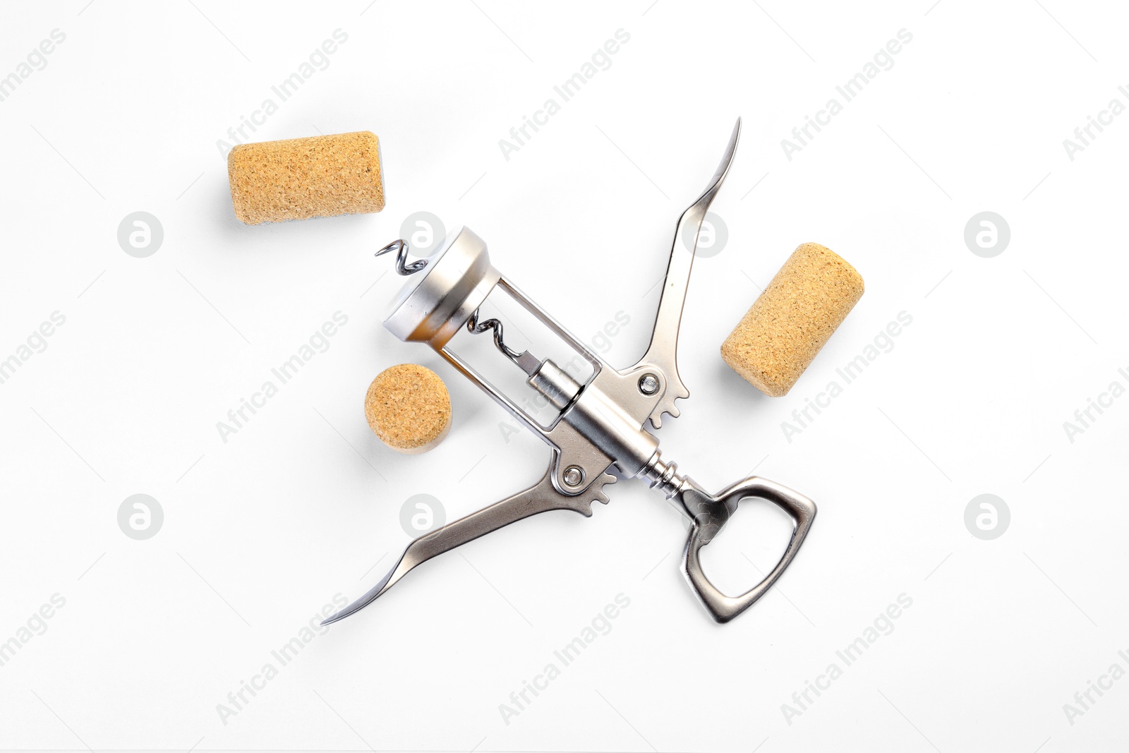 Photo of Wing corkscrew and corks on white background, top view