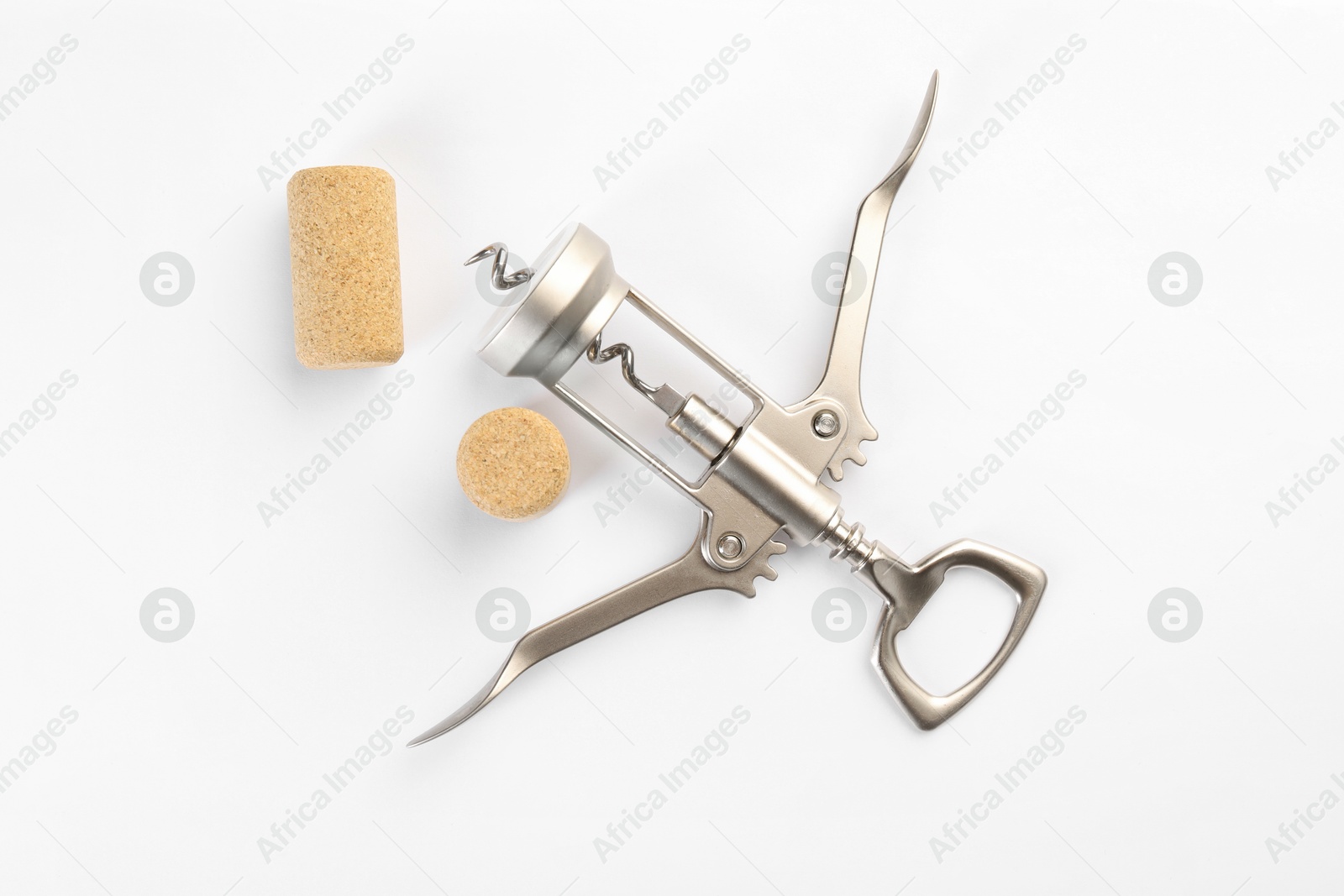 Photo of Wing corkscrew and corks on white background, top view