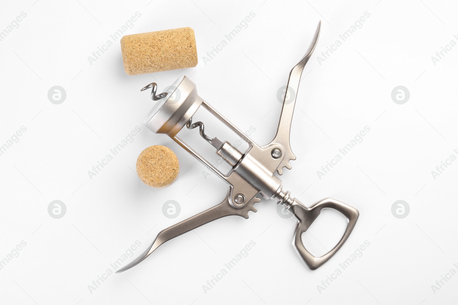 Photo of Wing corkscrew and corks on white background, top view