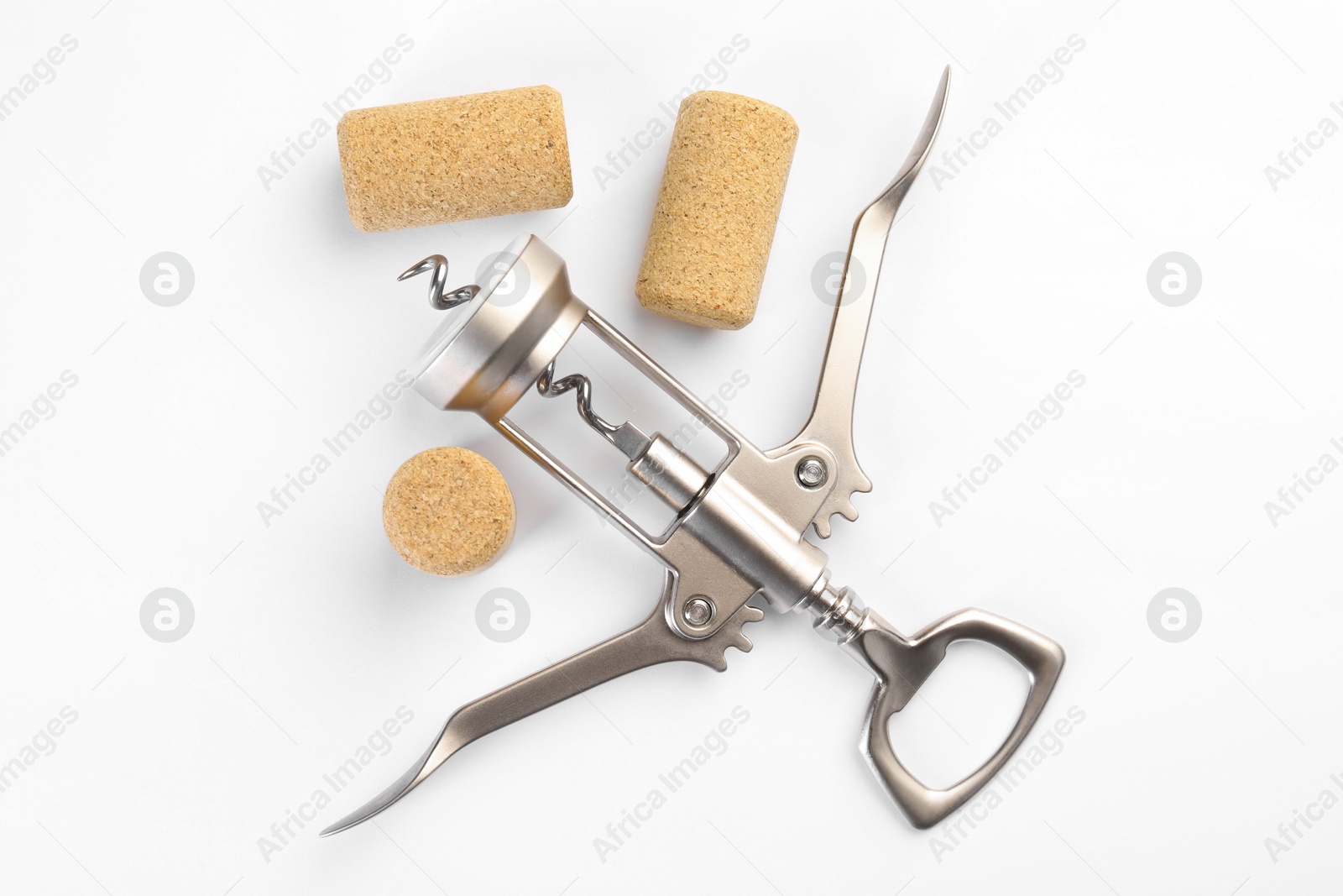 Photo of Wing corkscrew and corks on white background, top view