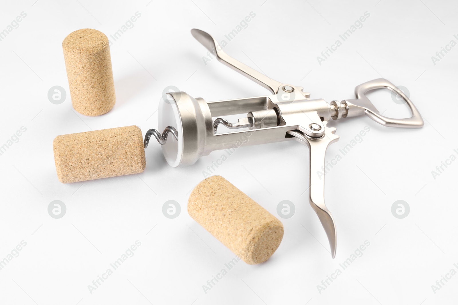 Photo of Wing corkscrew and corks on white background