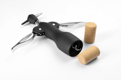 Photo of Wing corkscrew and corks on white background