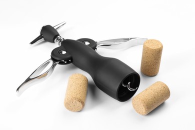 Photo of Wing corkscrew and corks on white background