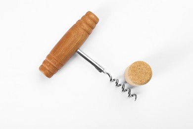 Photo of Corkscrew and cork on white background, top view