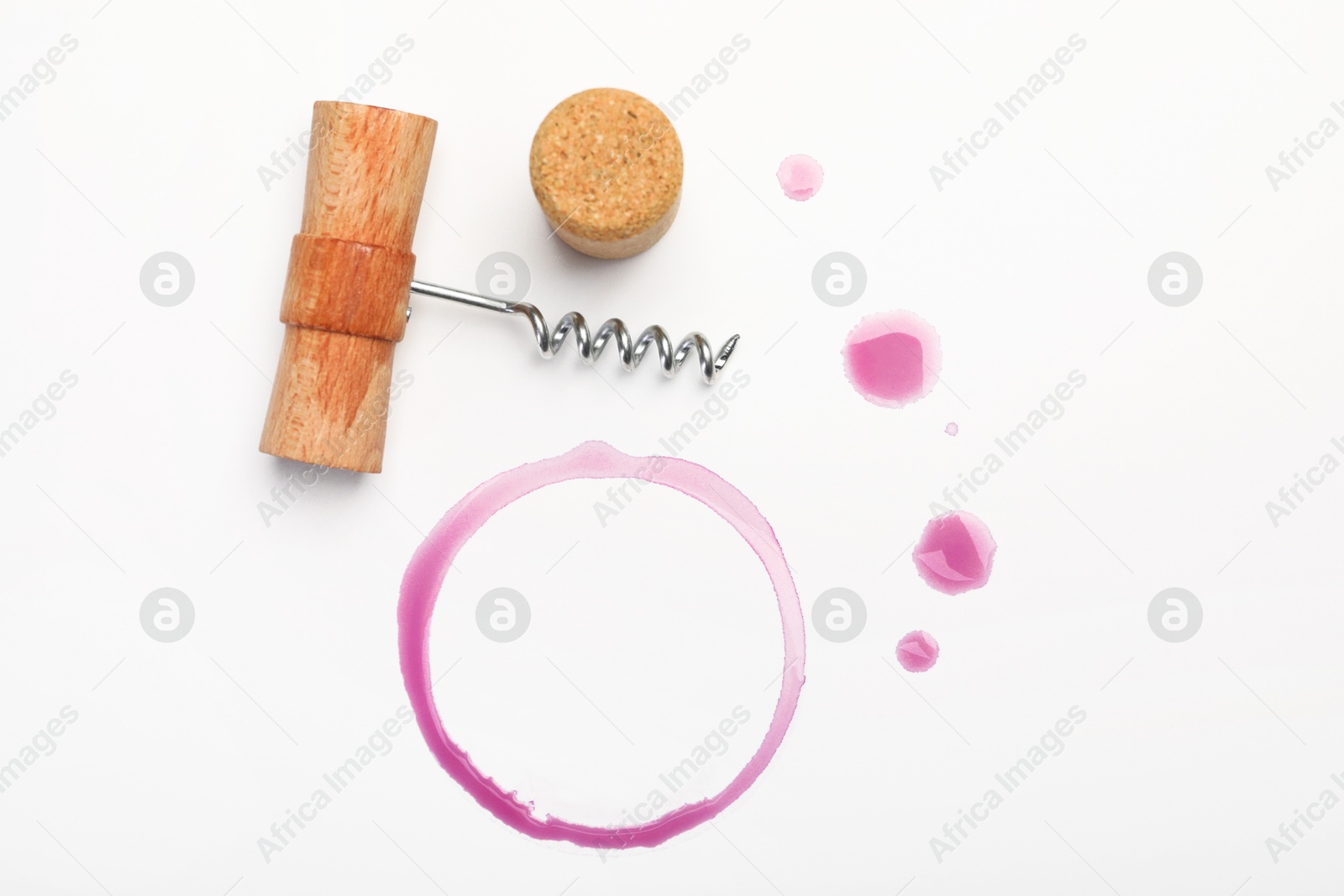 Photo of Corkscrew, cork and red wine stains on white background, top view