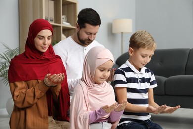 Photo of Happy Muslim family praying together at home