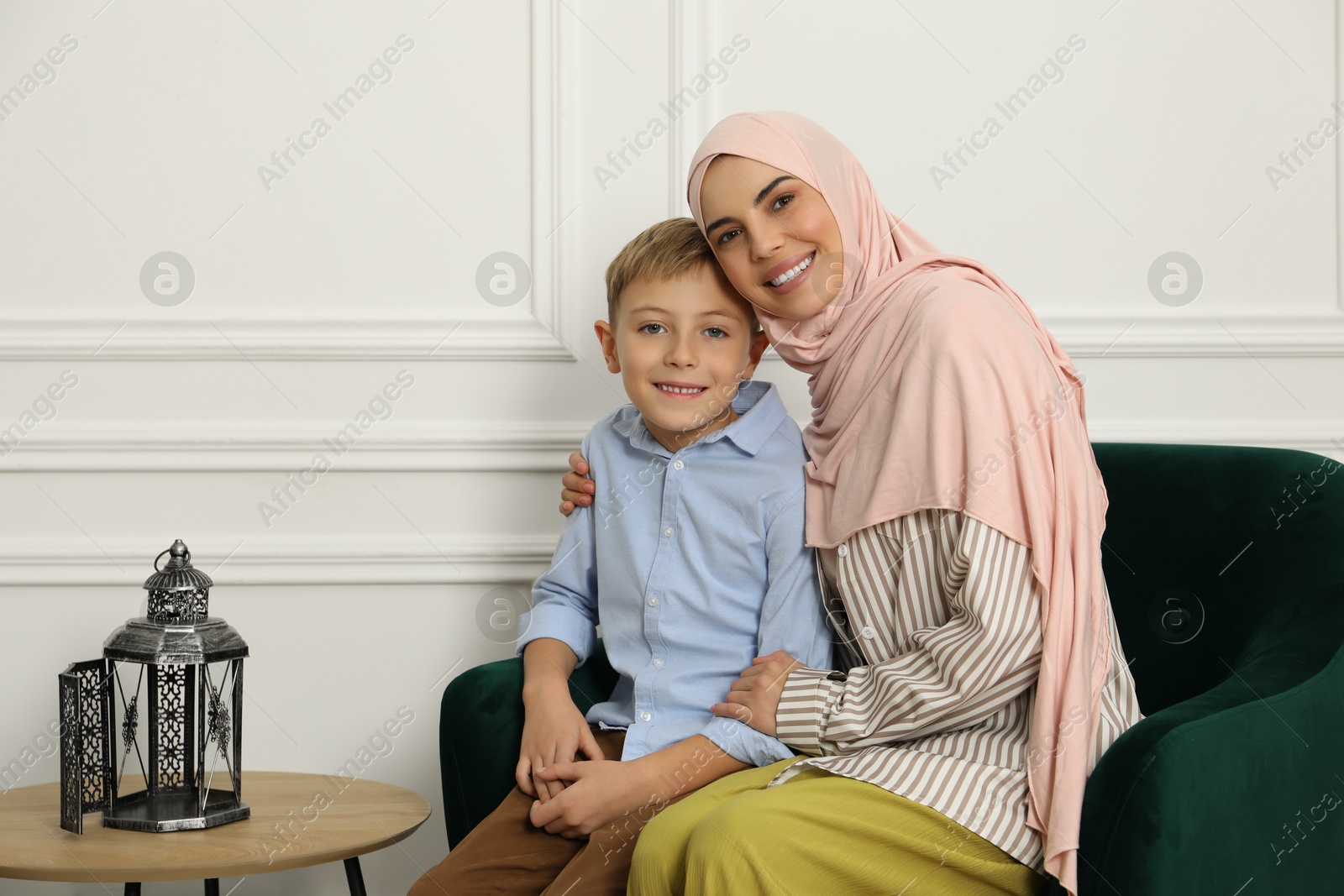 Photo of Muslim woman and her son spending time together at home