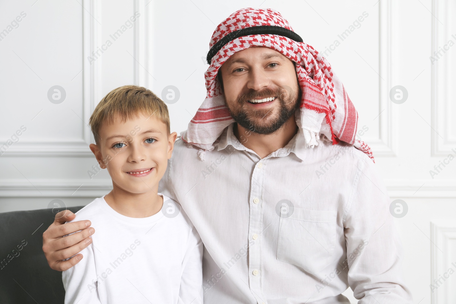 Photo of Muslim man and his son spending time together at home