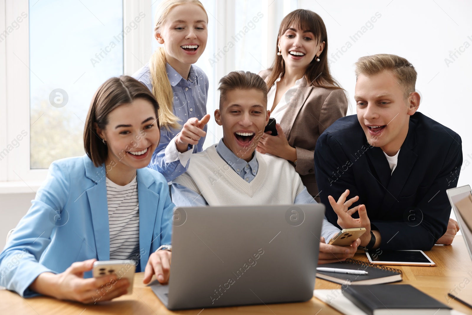 Photo of Group of people using different gadgets at wooden table in office. Modern technology