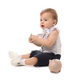 Photo of Little baby with money and piggybank on white background