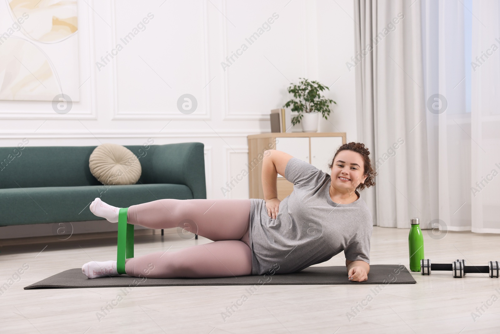 Photo of Woman training with resistance band at home