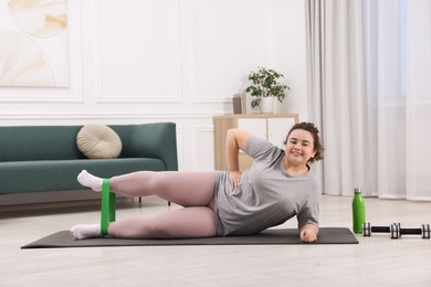 Photo of Woman training with resistance band at home