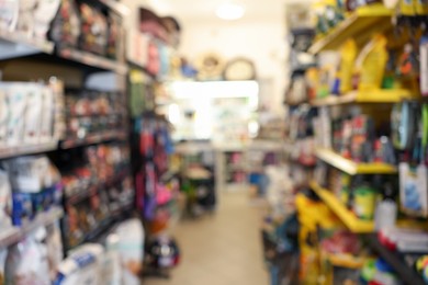 Photo of Blurred view of shelves with different products in pet shop