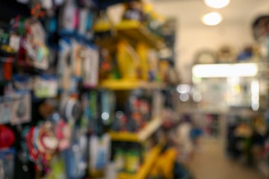 Photo of Blurred view of shelves with different products in pet shop