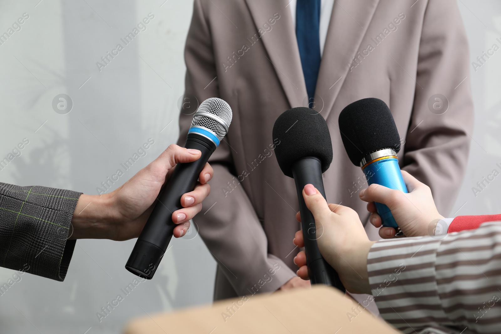 Photo of Group of journalists interviewing businessman indoors, closeup