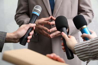 Photo of Group of journalists interviewing businessman indoors, closeup