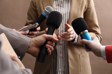 Photo of Group of journalists interviewing businesswoman on beige background, closeup