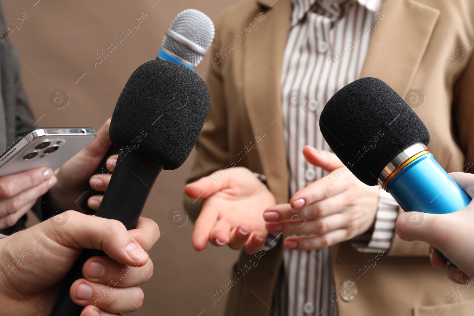 Photo of Group of journalists interviewing businesswoman on beige background, closeup